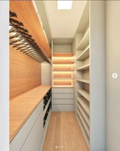 this is an image of a walk in closet with wood flooring and shelving