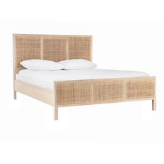 the bed is made with wicker and white pillows