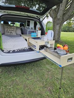 the back end of a van with an open trunk and bed on it's side