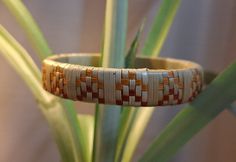 a woven bracelet sitting on top of a plant