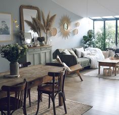 a living room filled with lots of furniture and decor on top of a hard wood floor