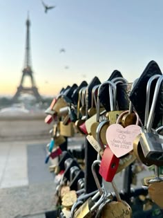 many padlocks are attached to the fence in front of the eiffel tower