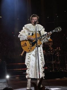 a man with a guitar on stage at a concert