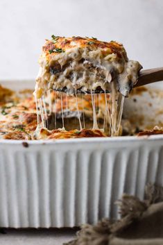 a casserole dish filled with lasagna covered in melted cheese and mushrooms