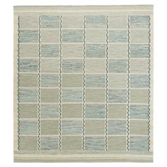 an area rug with blue and green squares on it, in the middle of a white background