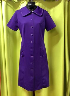 "Incredible vintage grape coloured micro mini MOD dress. Lovely classic shape with ten sweet purple buttons down the front and two faux pockets with button details also. The oversized collar and white stitching make the purple pop and really adds to the overall look. All measurements taken with garment laying flat.  PIT TO PIT 18\" SHOULDER TO SHOULDER 15.5\" SLEEVE LENGTH 8\" COLLAR TO HEM 37\" HEM WIDTH 24\" WAIST 16\"" Retro Collared Dresses With Pockets, Purple Short Sleeve Dress With Buttons, Casual Purple Dress With Button Closure, Fitted Purple Collared Dress, Purple Fitted Collared Dress, Purple Button-up Dress For Spring, 60s Purple Dress, Vintage Purple Tops With Button Closure, Purple Button-up Daywear Dress