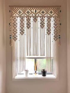 a window with some beads hanging from it's side and a potted plant on the other side