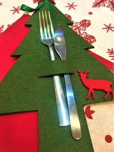 a fork, knife and spoon sitting on top of a christmas tree shaped placemat