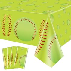 a green table cloth with baseballs on it and four napkins in the shape of balls