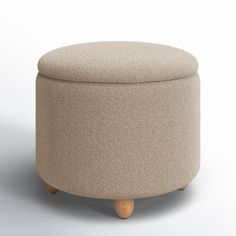 a round ottoman with wooden legs and a beige upholstered cover on the top