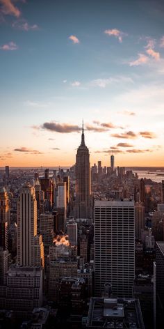 the skyline of new york city at sunset, with empire building in the foreground