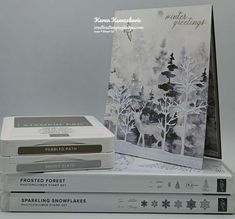 three books are stacked on top of each other in front of a white background with trees and snowflakes