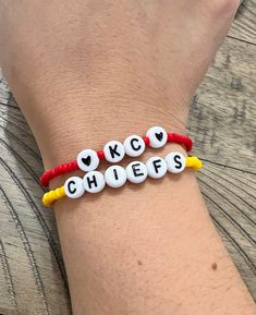 "Show your game-day spirit with this set of beaded stretchy bracelets.  This comes with one bracelet with the word \"KC\" and two hearts with red size 8/0 seed beads and one bracelet with the word \"Chiefs\" with yellow size 8/0 seed beads. HOW TO ORDER In the Personalization Box, please put your bracelet size. HOW TO MEASURE YOUR WRIST Use a flexible measuring tape. If you do not have one, use a piece of string, then measure against a ruler. 1. Measure your wrist where you would like the bracel Kc Chiefs Bracelet, Game Day Bracelets With Letter And Round Beads, Red Beaded Bracelets With Letter Beads For Game Day, Team Spirit Letter Beads Bracelets As Gift, Team Spirit Letter Beads Bracelets For Gift, Adjustable Letter Beads Stretch Bracelet For Sports Events, Personalized Adjustable Team Spirit Stretch Bracelet, Personalized Adjustable Stretch Bracelet For Game Day, Personalized Adjustable Stretch Bracelet For Team Spirit