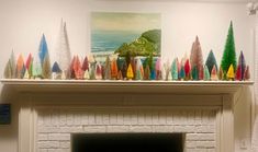 there are many colorful trees on top of the fireplace