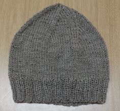 a gray knitted hat sitting on top of a wooden floor