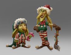 two christmas figurines are standing next to each other, one is holding a candy cane