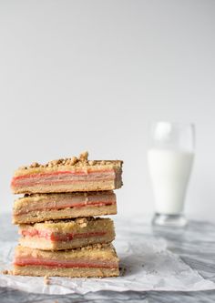 three sandwiches stacked on top of each other next to a glass of milk