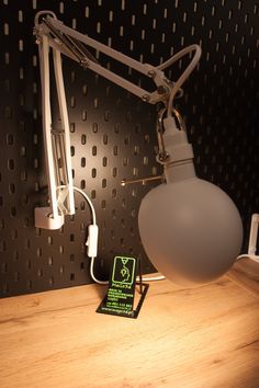 a light that is on top of a wooden table next to a phone charger