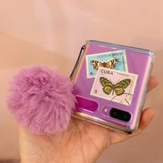 a purple case with a fuzzy pom - pom attached to it