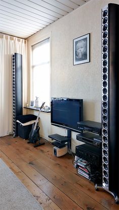 a living room filled with furniture and a flat screen tv on top of a wooden floor