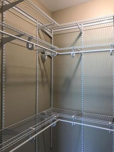 an empty closet with shelves and wire shelving