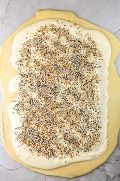 an uncooked pizza crust covered in cheese and sprinkles