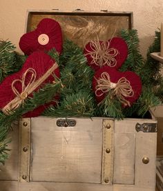 christmas decorations in an old trunk with twine and red heart shaped ornaments on top