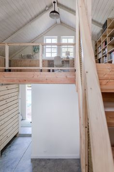 an open loft with stairs leading up to the second floor and another room in the background