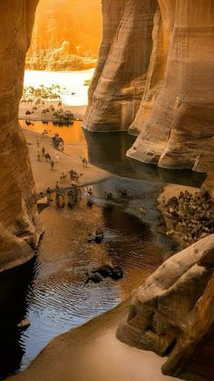 an image of the inside of a cave with water and people walking around in it