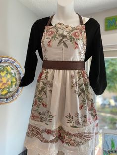 a mannequin wearing an apron and dress with flowers on it's chest