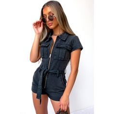 A Must-Have, Effortlessly Cool, And Edgy Chic Denim Playsuit From White Fox Boutique! One Of Those Trendy Hot Pieces That Are Easy To Throw On And Look Instantly Stylish. Designed With A Sexy Fitted Silhouette, Spread Collar, Zip-Up Closure, Cute Short Sleeve, Removable Waist Tie With Belt Loops, Two Front Cargo-Style Pockets, Two Side Pant Pockets, And A Rolled Hem. Comfy And Super Fun Piece! It Will Look Equally Amazing With Sporty Shoes As It Is With A Pair Of Heels. Made From High-Quality De High Waist Fitted Utility Jumpsuits And Rompers, Fitted High Waist Utility Jumpsuits And Rompers, Chic Black Denim Jumpsuit, Black High Rise Denim Jumpsuit For Spring, Spring Black High Waist Denim Jumpsuit, Chic Black Denim Jumpsuit With Pockets, Black High Waist Denim Jumpsuit For Summer, Black High Rise Fitted Denim Jumpsuit, Spring High Waist Black Denim Jumpsuit