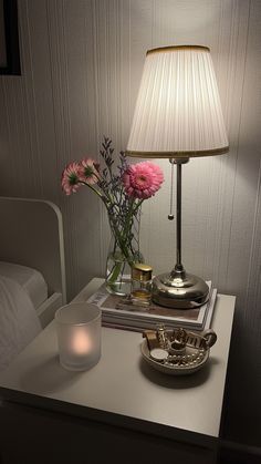 a table with a lamp and some flowers on it