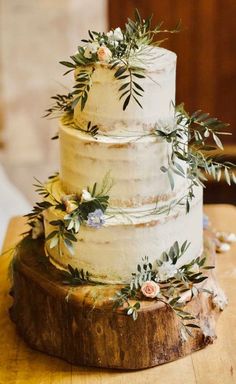 a white wedding cake with greenery on top