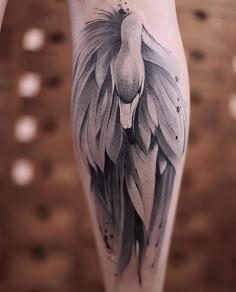 a woman's leg with an artistic tattoo design on the thigh, and wings