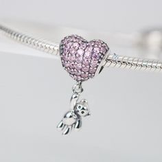 This is charm only, bracelet is sold separately. Bring some extra joy and sparkle to your Valentine's Day with this exquisite heart and teddy bear combo charm. Perfect for adding to a bracelet or necklace, this solid 925 sterling silver charm features a dazzling pink cubic zirconia pave heart and a tiny teddy bear for a touch of cuteness. Show your love with this adorable charm, plated with shiny platinum to keep it shining for years to come. Materials: 925 sterling silver, cubic zirconiaFinish: platinum plateDimensions: 0.82 x 0.42 x 0.30 inHole size: 0.18 in Jewelry Care: See more information about how to care for your jewelry here. Shipping Policy: Orders will be shipped within 1-3 business days. Economy shipping will take 7-14 days to arrive and standard shipping is 1- 4 days for U.S. Silver Heart Charm For Birthday, Pink Sterling Silver Dangle Charms, Silver Heart Charms For Birthday, Sterling Silver Charms For Birthday And Valentine's Day, Pink Heart-shaped Jewelry With Dangling Charms, Cute Silver Dangle Charms, Pink Sterling Silver Charm Bracelet With Heart, Pink Heart Sterling Silver Charms, Sterling Silver Pink Heart Charm Bracelet