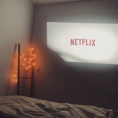 a bedroom with a bed and a projector screen on the wall next to it