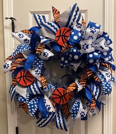 a blue and orange wreath with basketballs on it is hanging on the front door