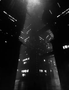 a black and white photo of the inside of a building with lights shining down on it