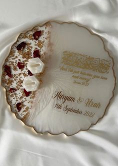 a wedding cake on a white plate with gold trimmings and garnishes