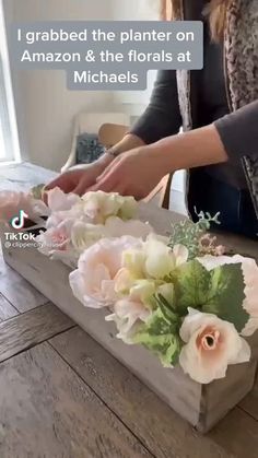 a woman is cutting flowers on a wooden table with text that reads, i grab the planter on amazon & the florals at michael's