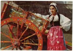 a woman standing next to a wooden cart