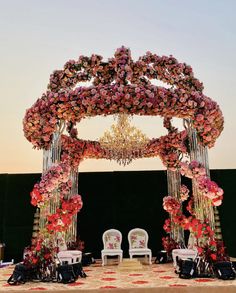 an outdoor wedding setup with flowers and chandelier