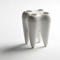 two toothbrush holders sitting next to each other on a white surface with three holes in the middle