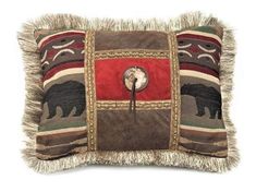 a brown and red pillow with a black bear on the front, fringe trim around the edges