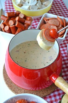 a red pot filled with soup sitting on top of a table next to other food