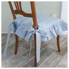 a wooden chair with a blue ruffled seat cover