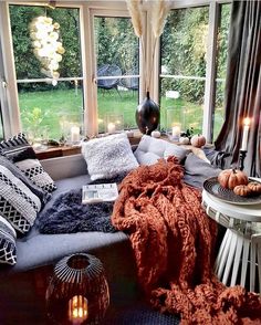 a living room filled with lots of furniture and candles on the windows sills