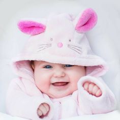 a smiling baby wearing a pink bunny outfit