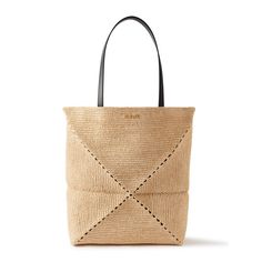 Loewe's 'Puzzle Fold' tote bag has a stylishly understated design that will work with all kinds of outfits. Made in collaboration with Paula’s Ibiza, it's been expertly crafted in Spain from raffia and is designed to fold completely flat for easy portability. Notice the brand's logo plaque on the top.