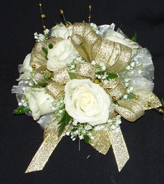 a bridal bouquet with white roses and gold ribbons